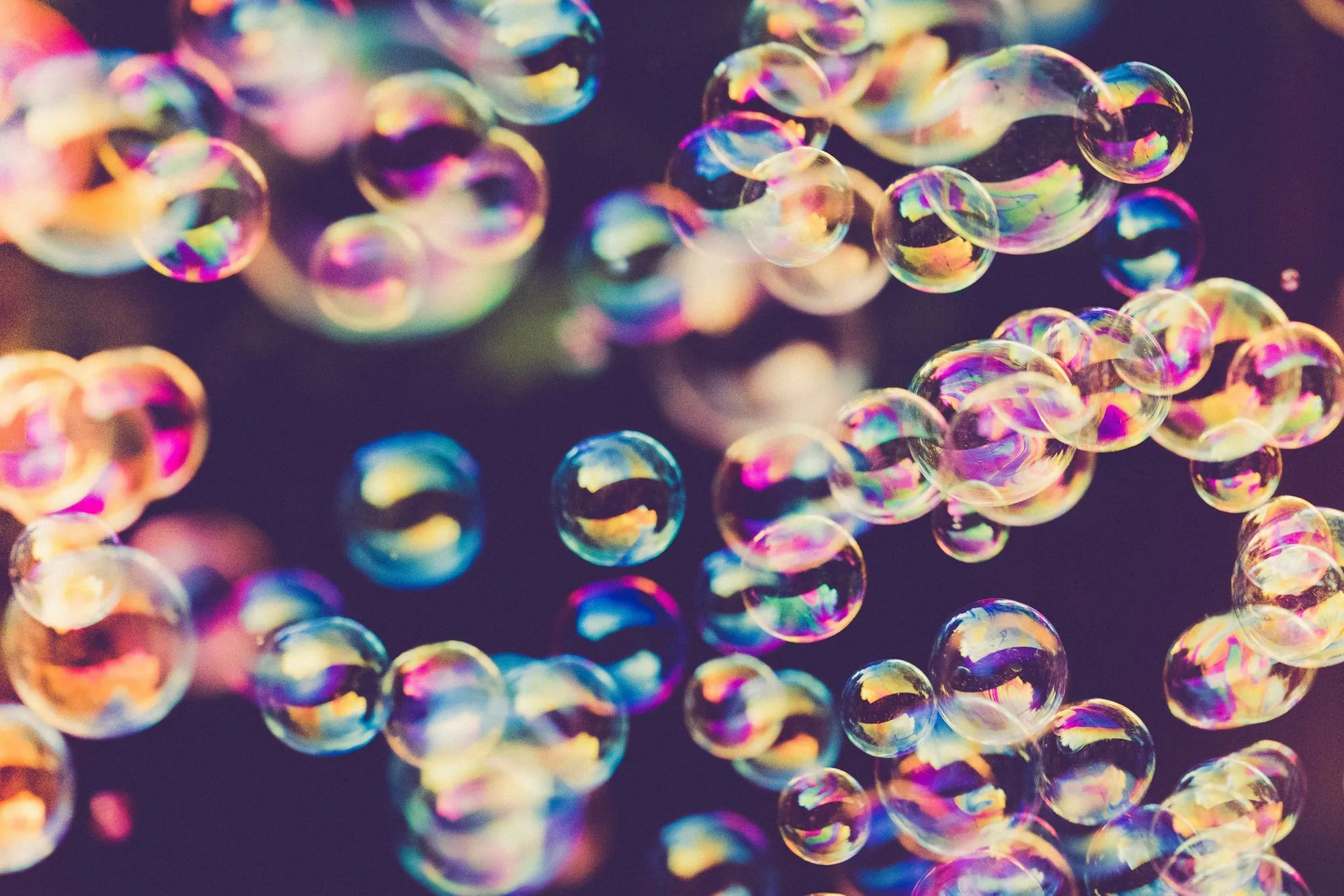 Colourful soap bubbles against a dark background.